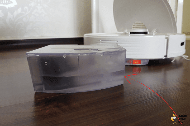 The water tank with remaining water is on the floor behind the Roborock Q7 Max.